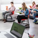 High school students using digital tablets in modern classroom.